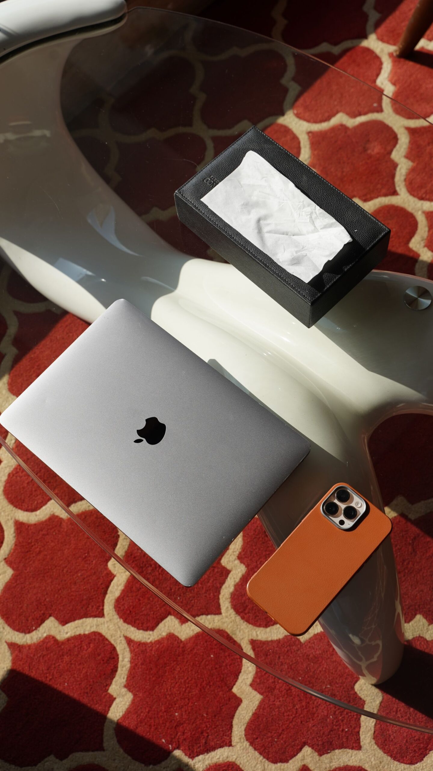 Modern workspace with a laptop and smartphone on a glass table, representing UI design tactics across devices