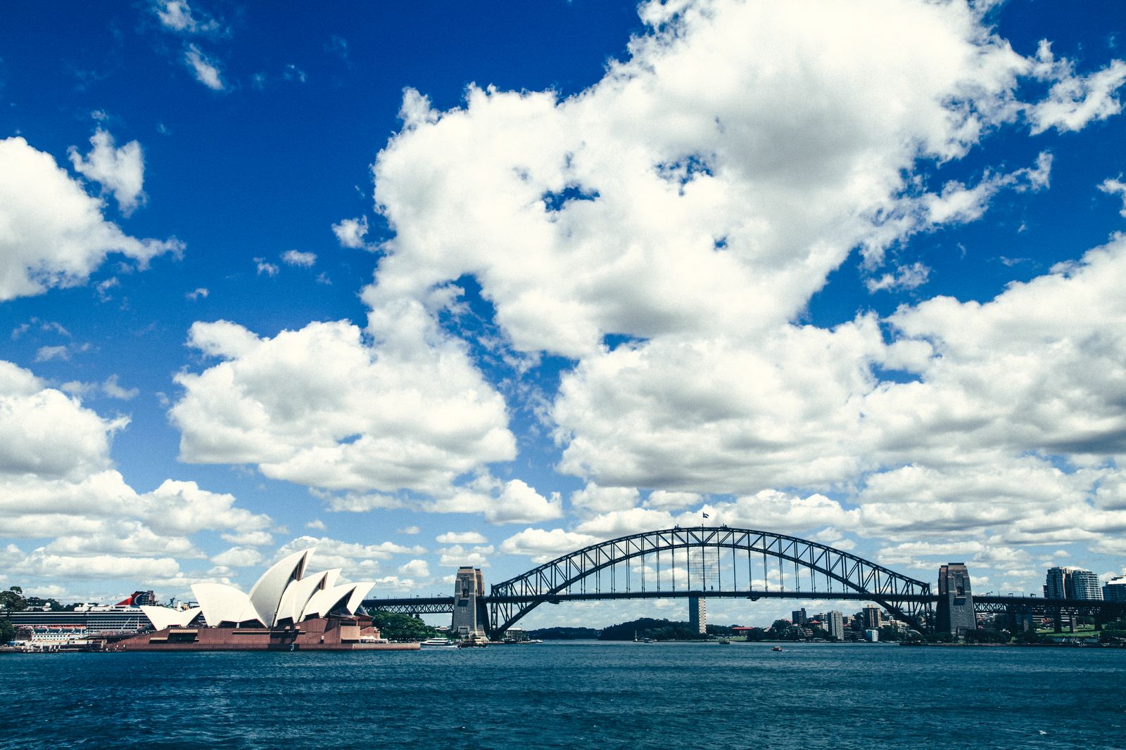 Sydney Opera House and Harbour Bridge under a blue sky, representing the UI/UX Architect job market in Sydney