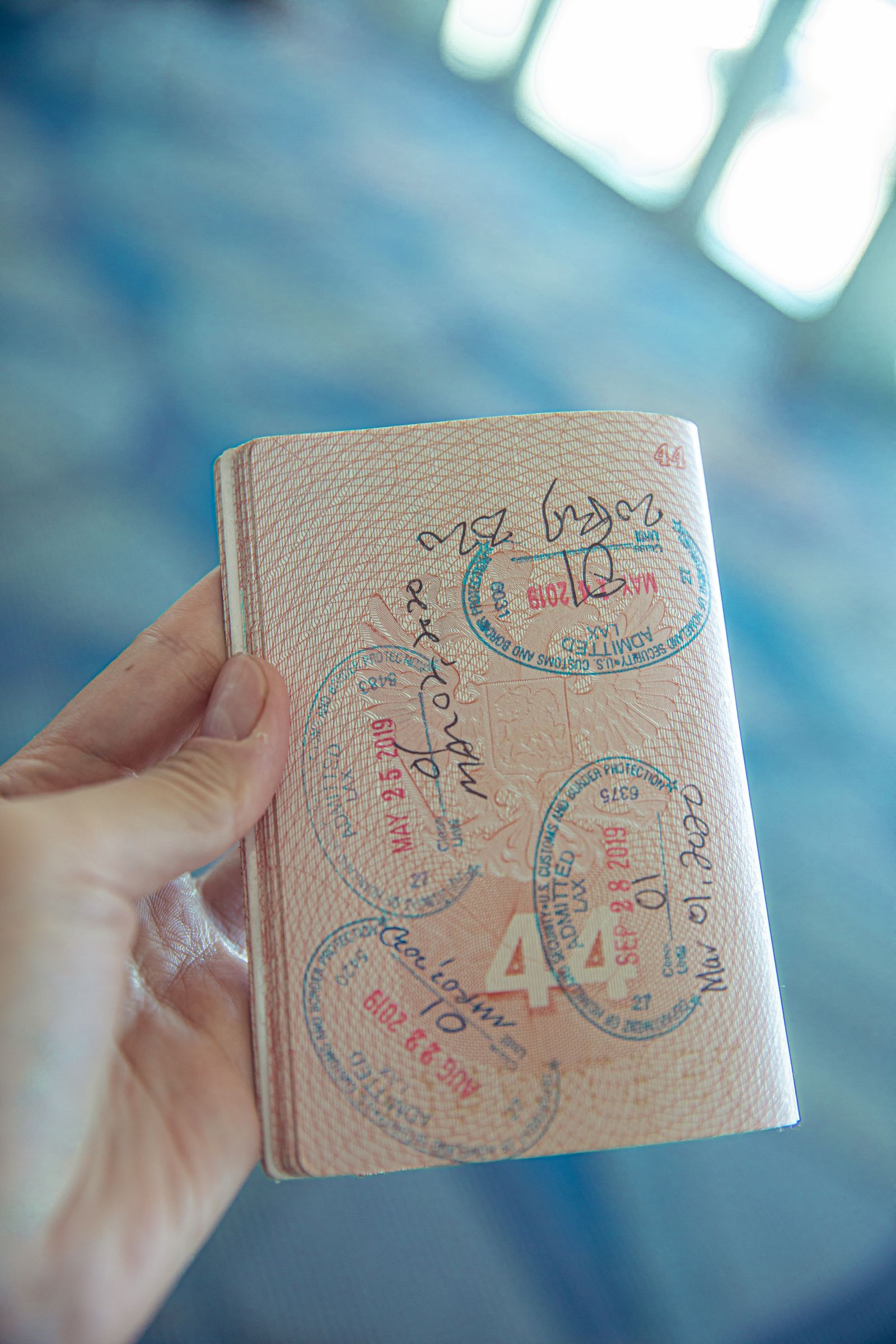 A hand holding an open passport filled with stamps, representing Australia's 2026 immigration changes