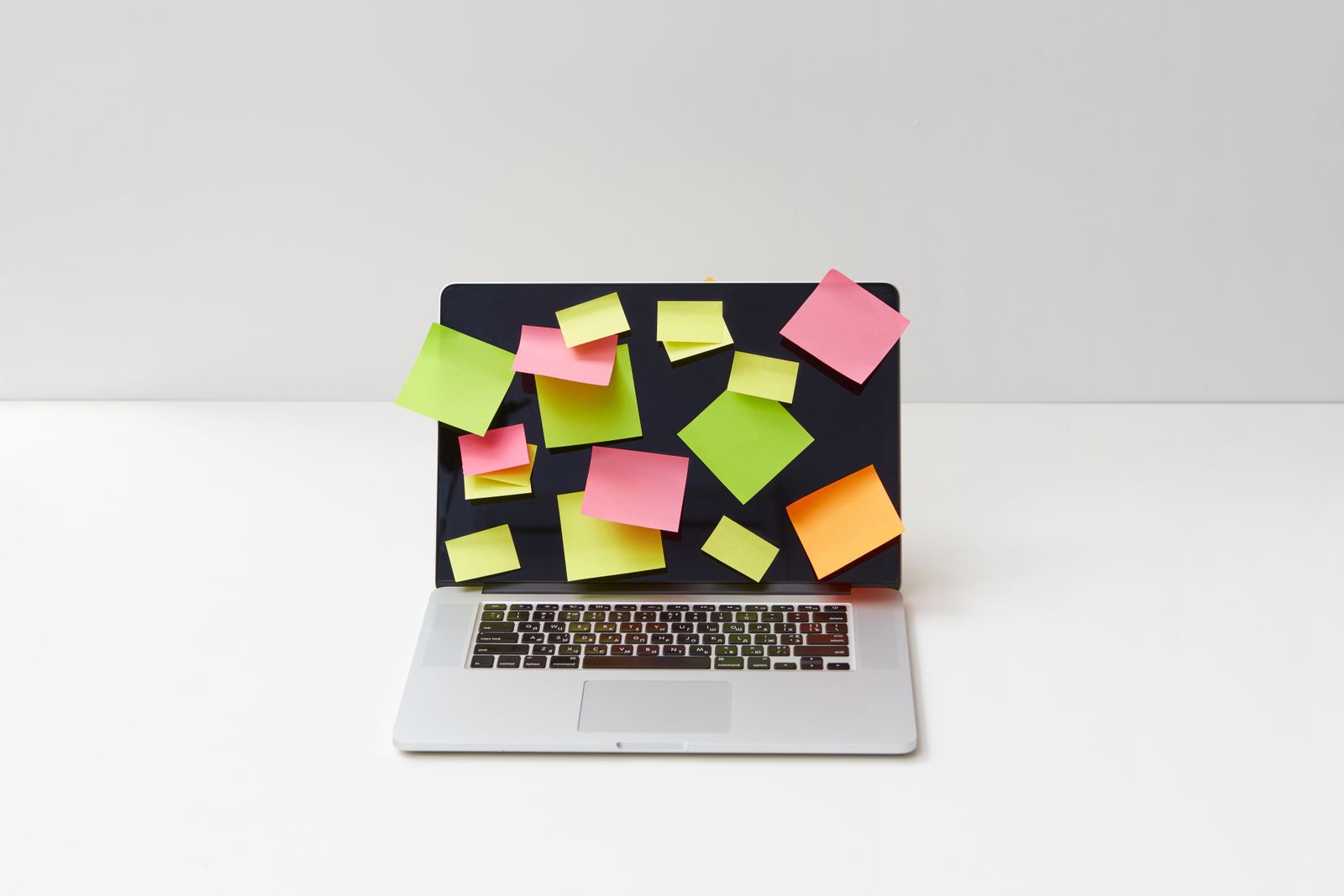 Laptop covered in colourful sticky notes, evoking a UI designer's daily craft and planning