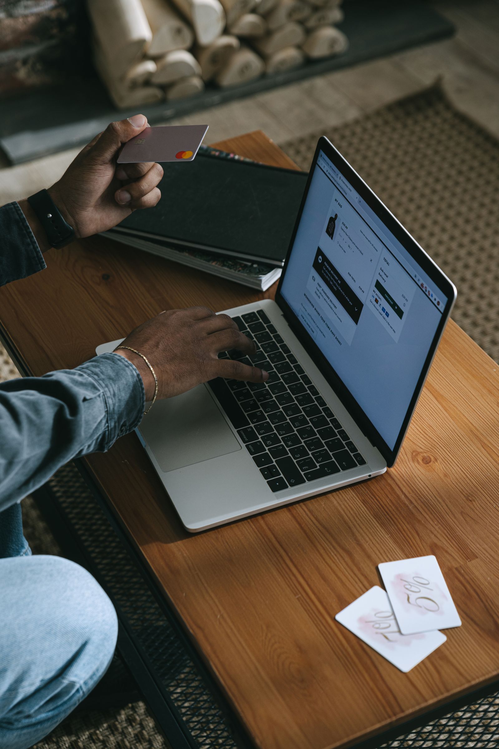 Person shopping online on a laptop while holding a credit card, representing e-commerce interface and trust
