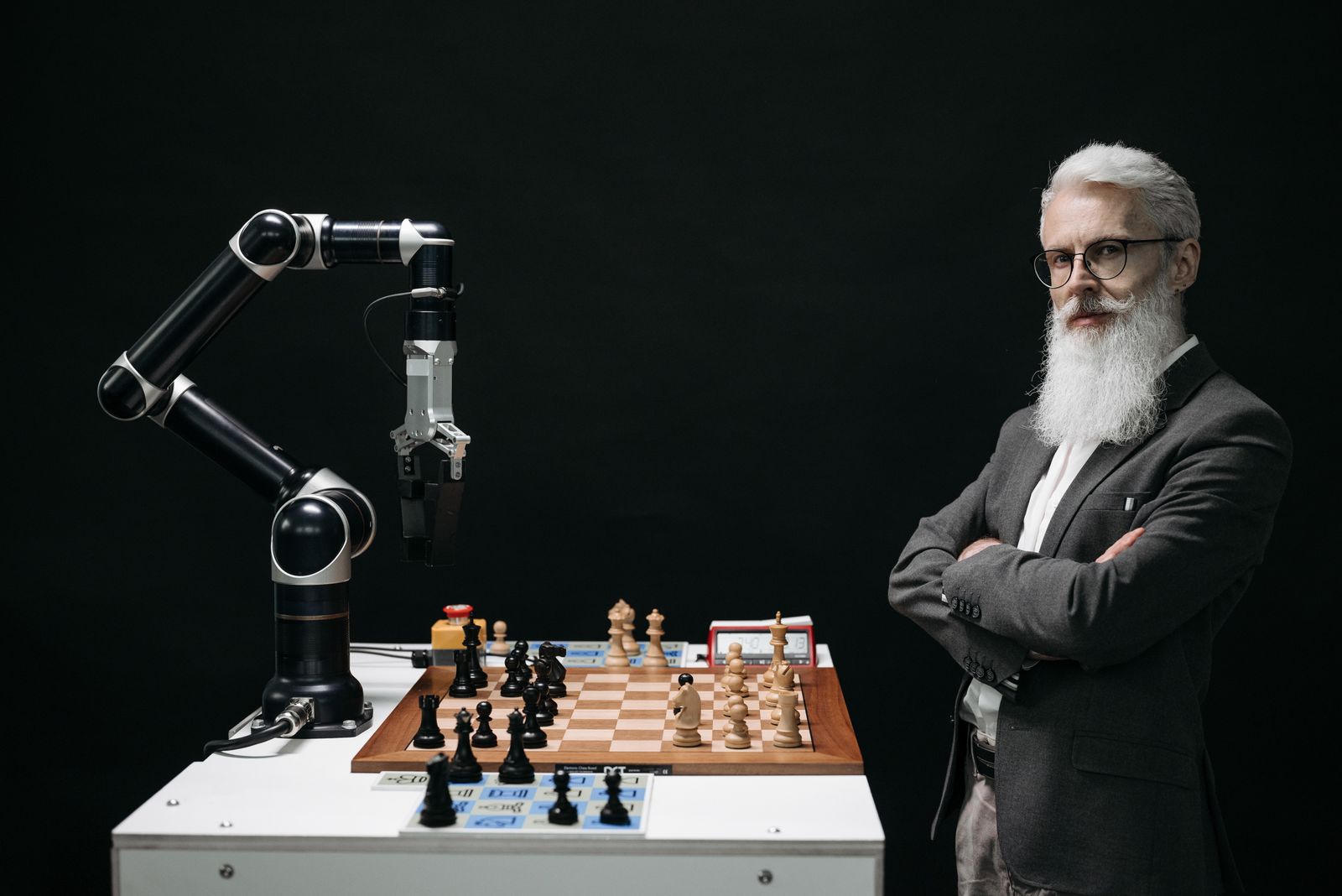 A person and a robotic arm playing chess, representing parallel AI agents versus human single-tasking