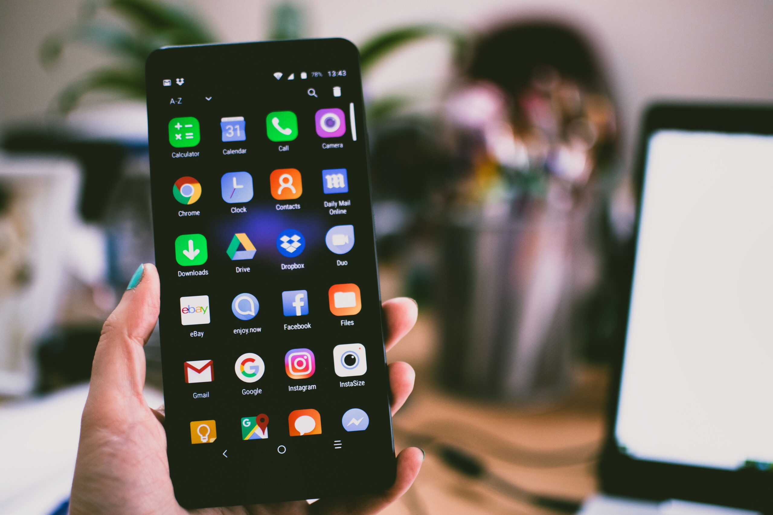 Person holding a smartphone with colourful app icons representing hyper-personalised adaptive user interfaces